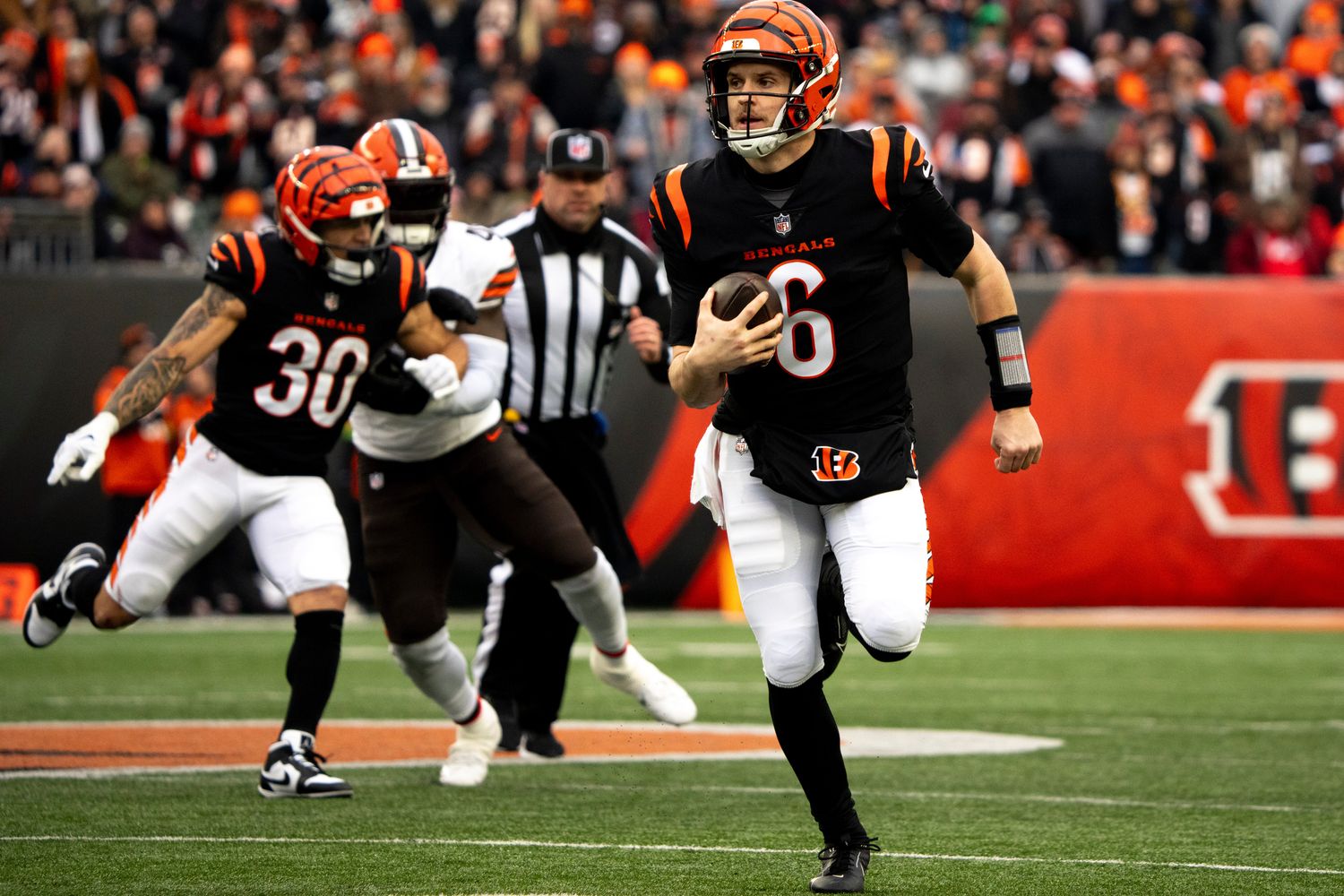 Cincinnati Bengals quarterback Jake Browning (6) runs for a first down in the second quarter of the NFL game between Cincinnati Bengals and Cleveland Browns at Paycor Stadium in Cincinnati on Sunday, Jan. 7, 2024.